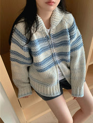 Person wearing a striped knitted cardigan in a neutral setting