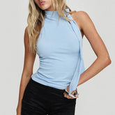 Model displaying a mock neck tie-up tank top in a solid color.