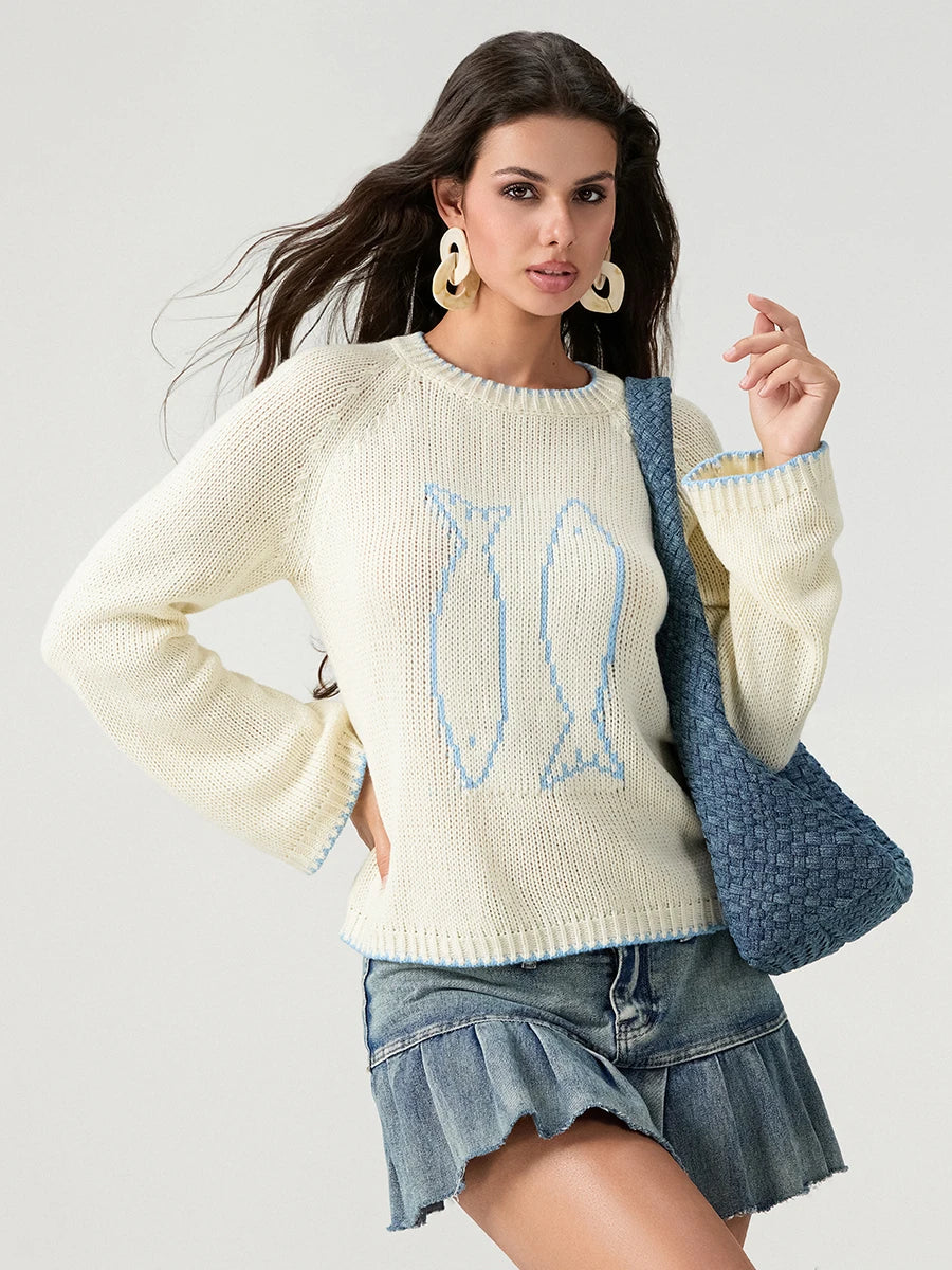 Woman wearing a cream sweater with bunny design and denim skirt, holding a blue bag.