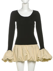 Mannequin wearing a black long-sleeve top with a beige skirt on a white background