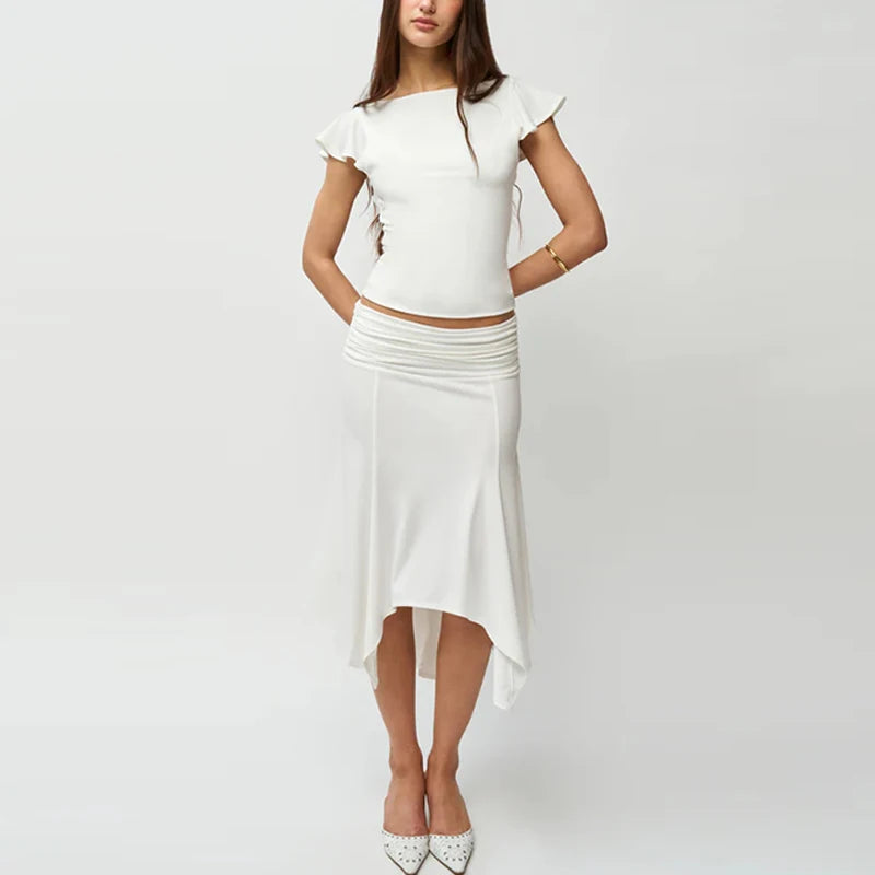 Woman wearing a white top and skirt on a plain background