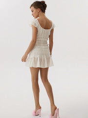 Woman wearing a white dress with pink shoes- back view