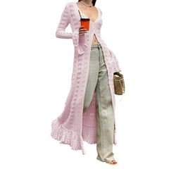 Person wearing a long pink cardigan over a white top, holding a red cup, with a white background.