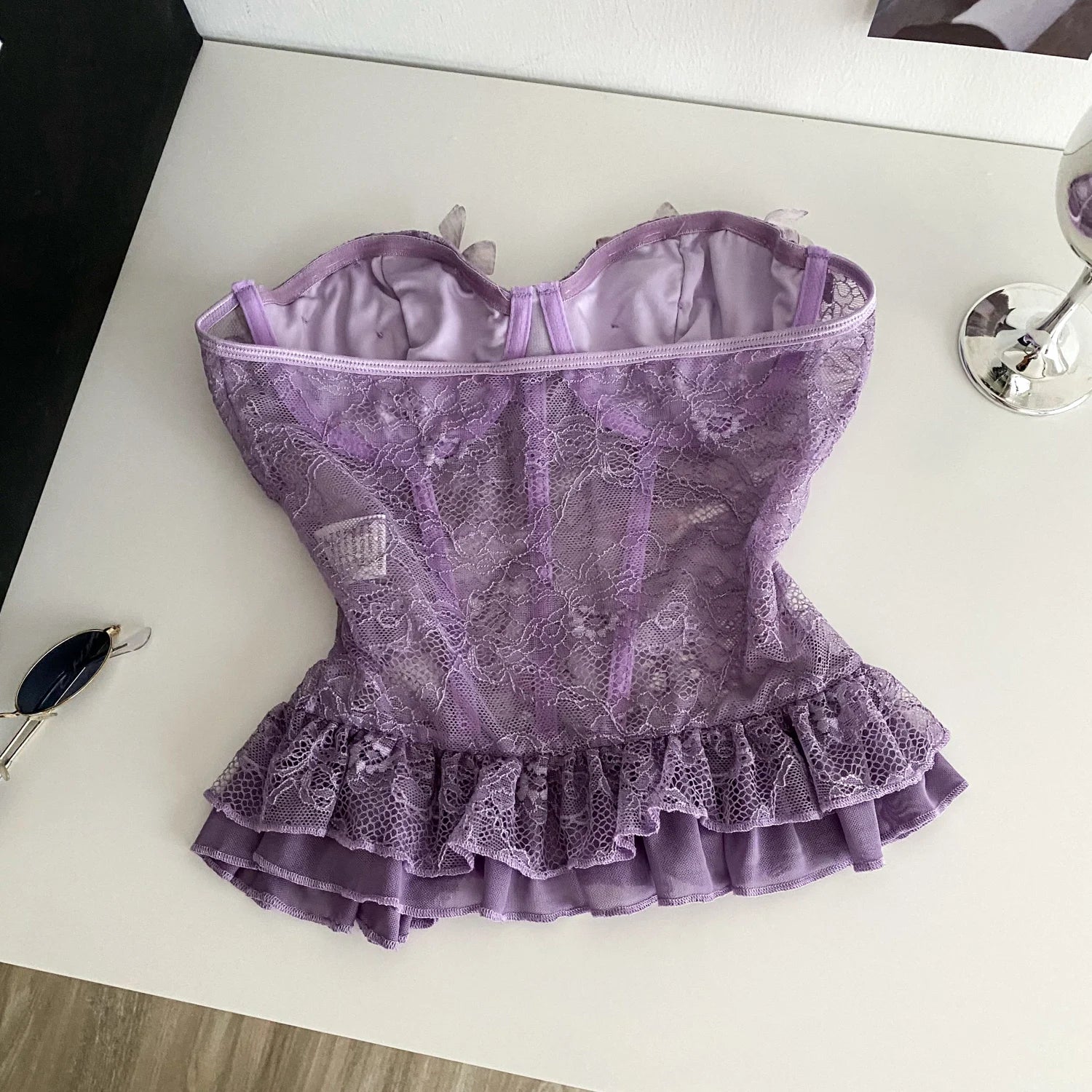 Purple lace corset on a white surface