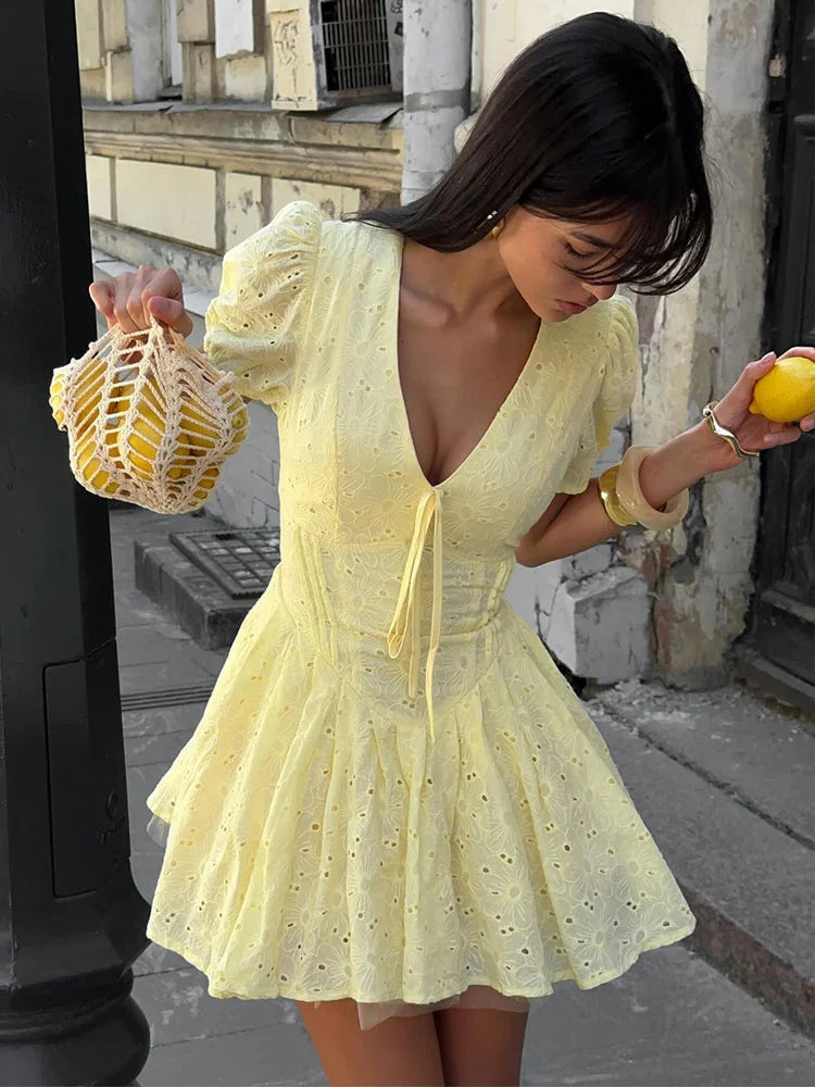 Women's yellow tie-up puff sleeve mini dress with a V-neck and A-line silhouette.