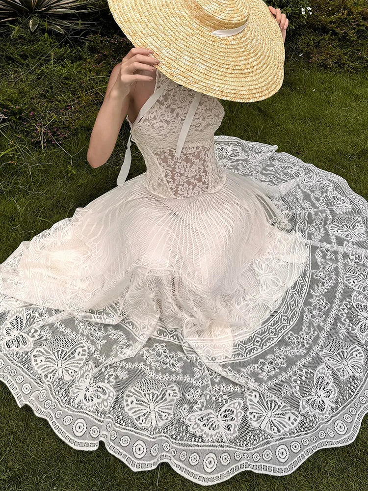 Person wearing a white lace dress and straw hat in an outdoor setting