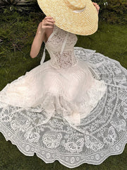 Person wearing a white lace dress and straw hat in an outdoor setting