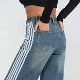 Blue jeans with white stripes on a plain background