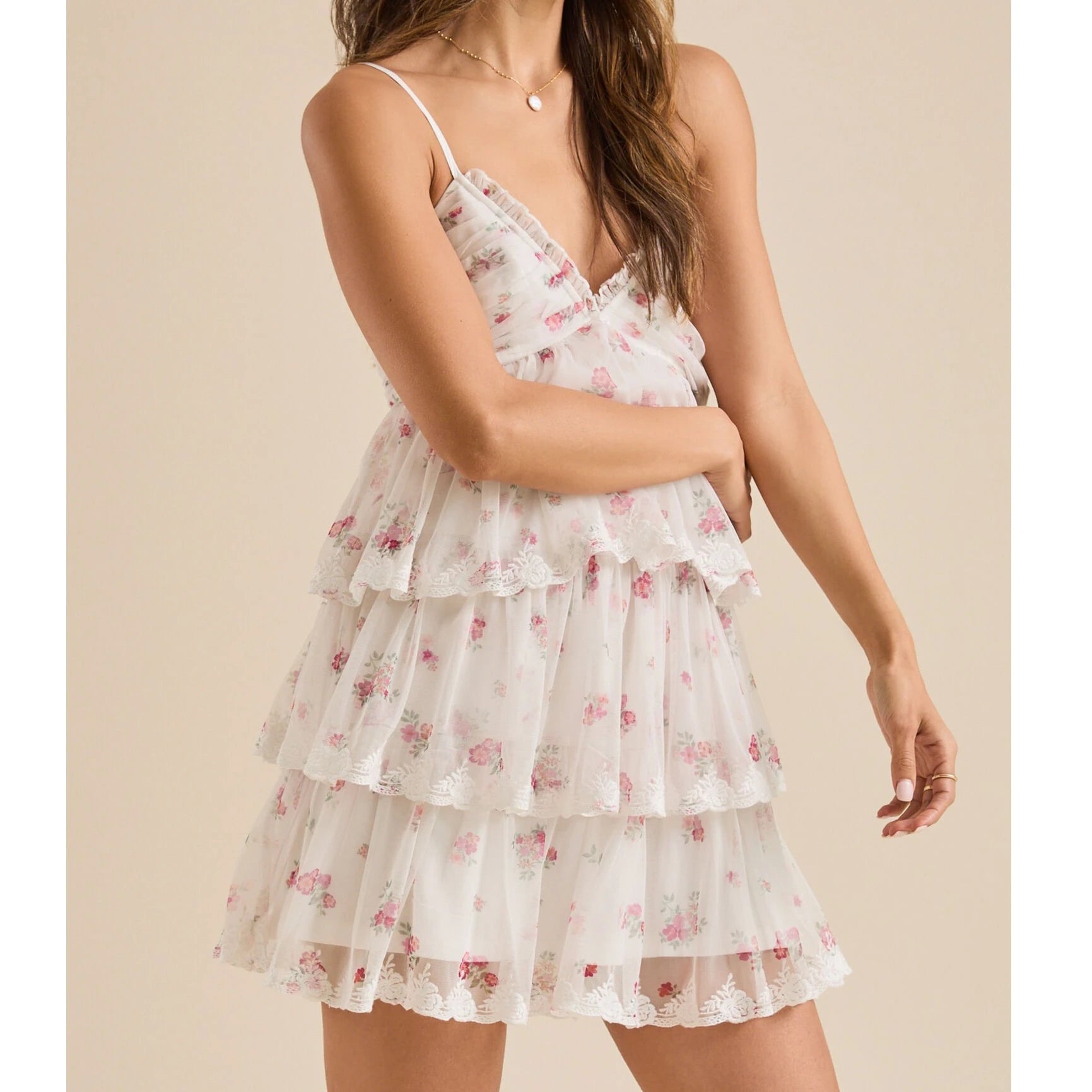 Woman wearing a floral tiered dress on a beige background