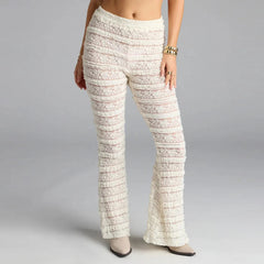 White lace pants worn by a person on a gray background