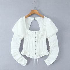 White long-sleeve blouse with puff sleeves, a square neckline, and a back keyhole cutout, hanging on a wooden hanger against a plain gray background.