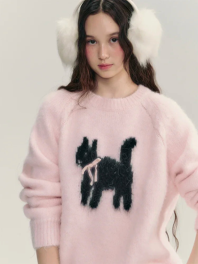 Person wearing a pink sweater with a black dog design and white ear muffs on a light gray background