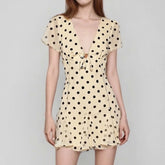 Beige dress with black polka dots on a gray background