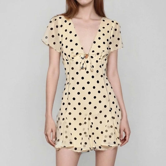 Beige dress with black polka dots on a gray background