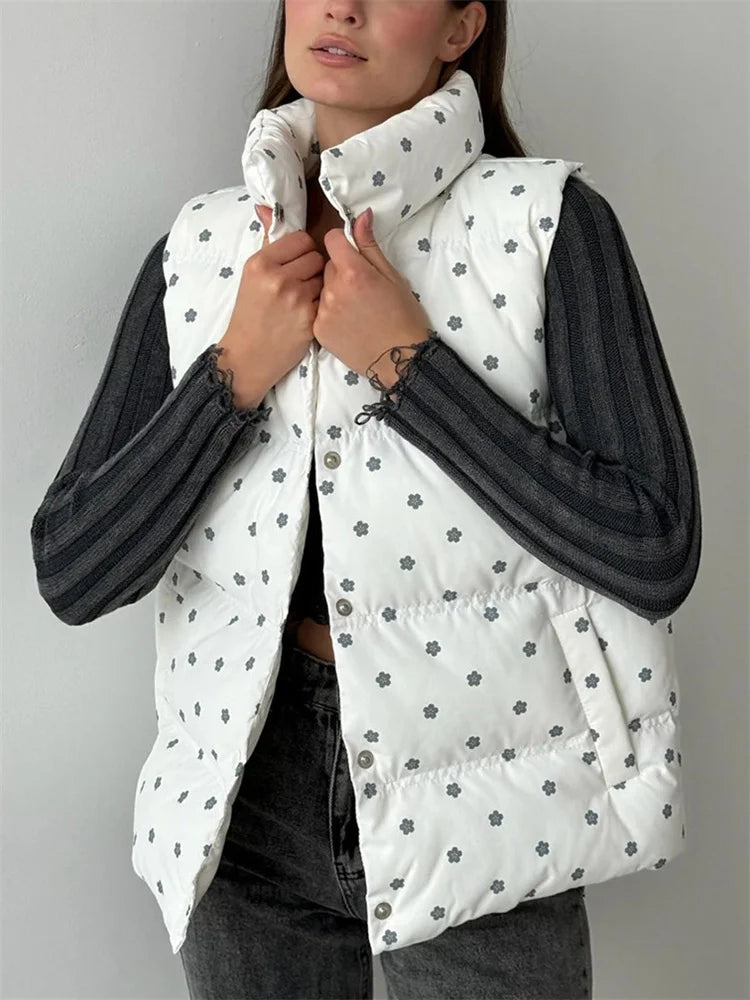 Person wearing a white puffer vest with black floral patterns on a gray background