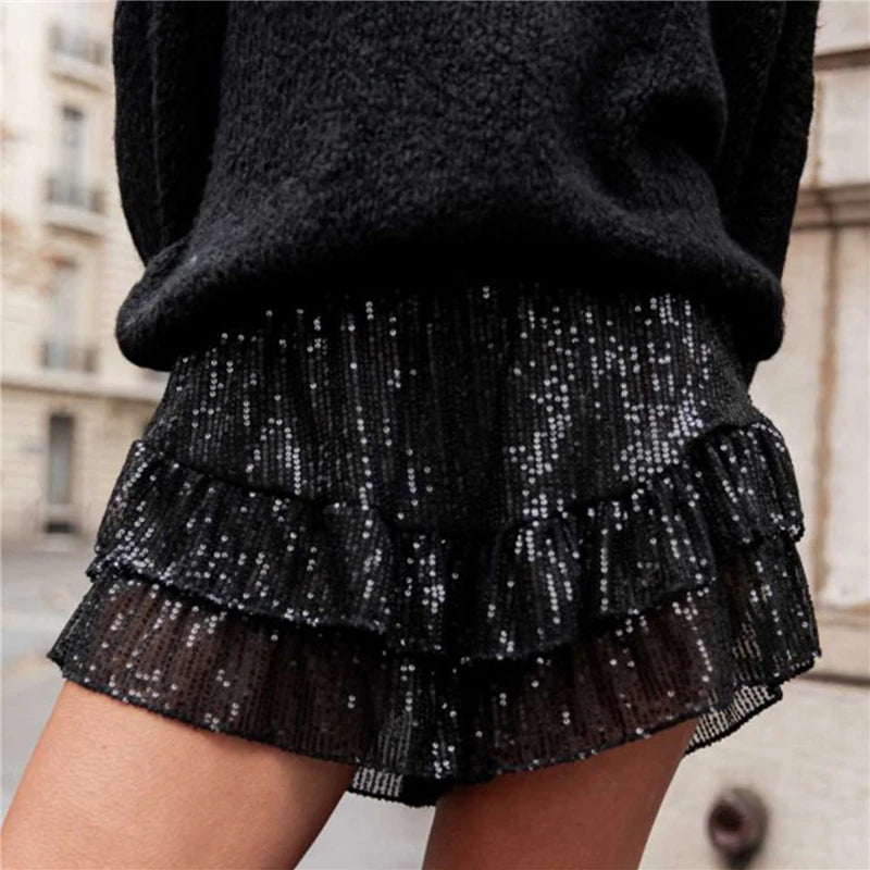 Black sequin skirt worn by a person with a blurred urban background