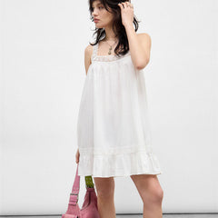 Woman wearing a white dress with a plain background