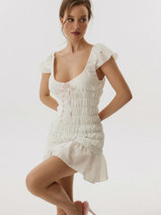 Woman wearing a white dress with ruffled sleeves-front view