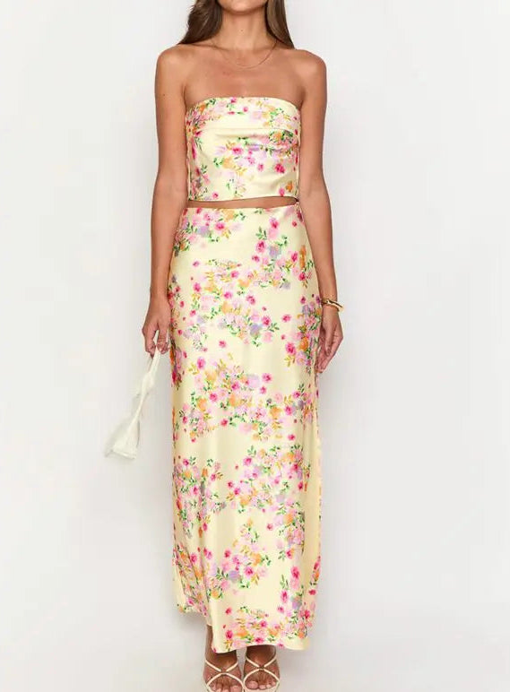 Woman wearing a floral strapless top and long skirt set on a white background