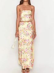 Woman wearing a floral strapless top and long skirt set on a white background