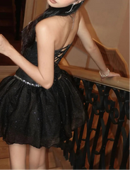 Person wearing a black dress with thin straps in an indoor setting
