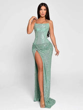 Woman wearing a sparkly green dress with a high slit on a white background
