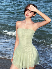 Woman in a light green dress standing by the ocean
