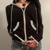 Black hoodie with lace trim on sleeves and bottom, worn by a person