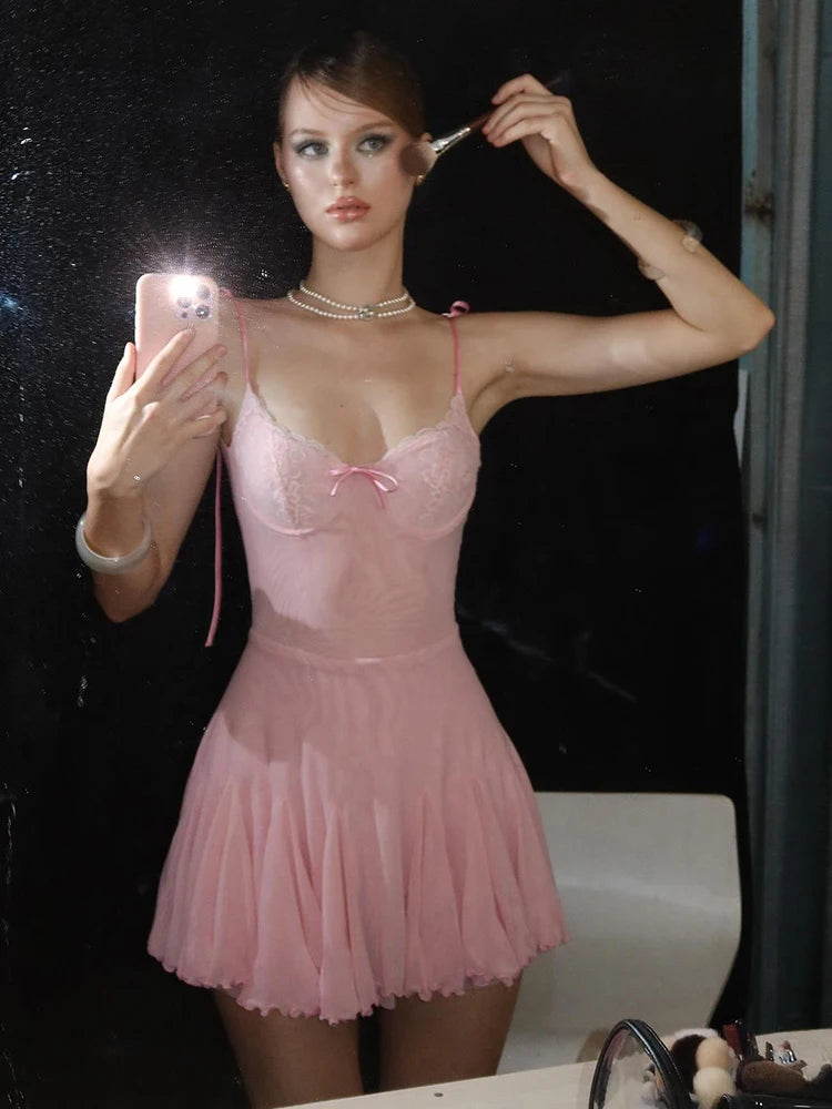 Person wearing a pink lace nightgown taking a mirror selfie.