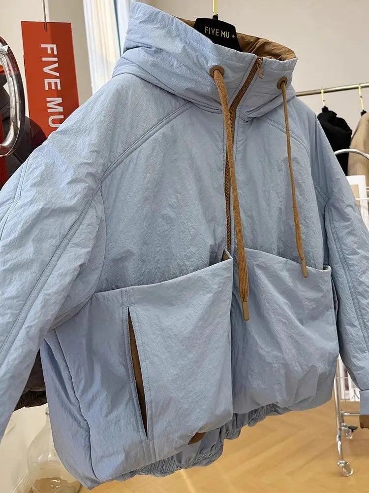 Light blue jacket with brown drawstrings on a mannequin in a store setting.