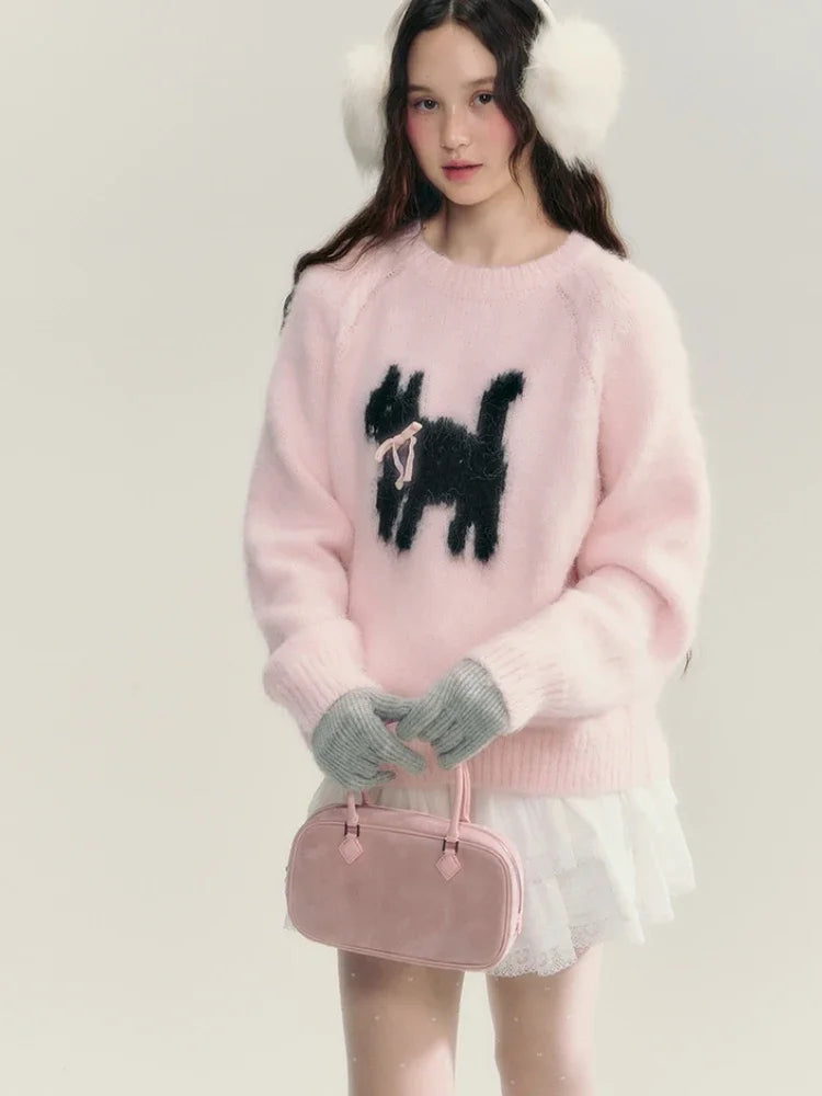Woman wearing a pink sweater with a black dog design, white shorts, and holding a pink handbag.