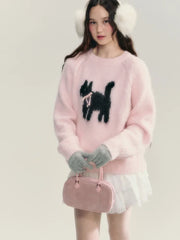 Woman wearing a pink sweater with a black dog design, white shorts, and holding a pink handbag.