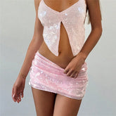 Person wearing a pink sequin top and skirt on a plain background