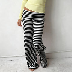 Person wearing black and white striped pants against a plain background