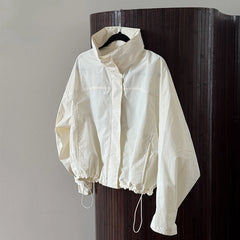 White jacket hanging on a wooden door against a gray wall