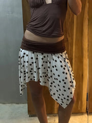 Women's polka dot low rise irregular short skirt with A-line silhouette.