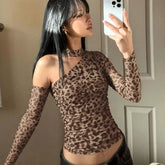 Woman taking a mirror selfie wearing a leopard print top.