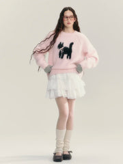 Person wearing a pink sweater with a black dog design and a white skirt on a light gray background