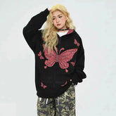 Person wearing a black hoodie with red butterfly designs on a white background