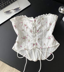 White lace corset with floral patterns on a black surface