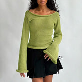 Woman wearing a green knitted sweater and black skirt