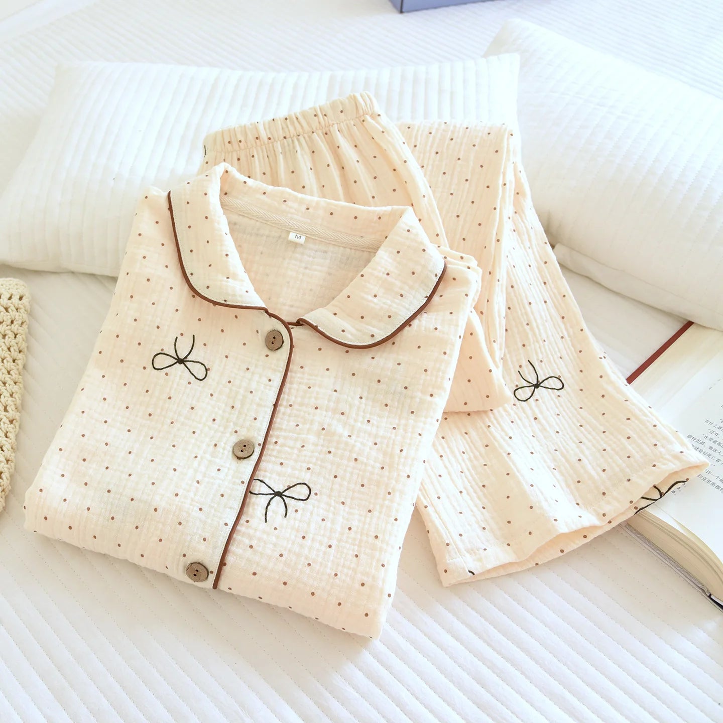Folded pajama set with bow details on a white surface