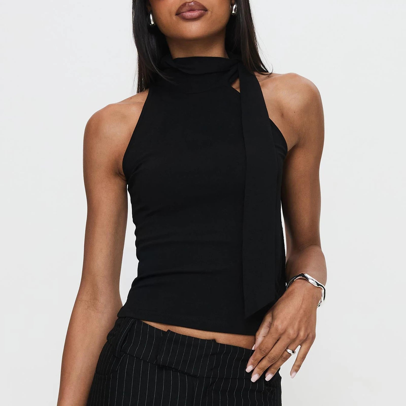 Model displaying a mock neck tie-up tank top in a solid color.