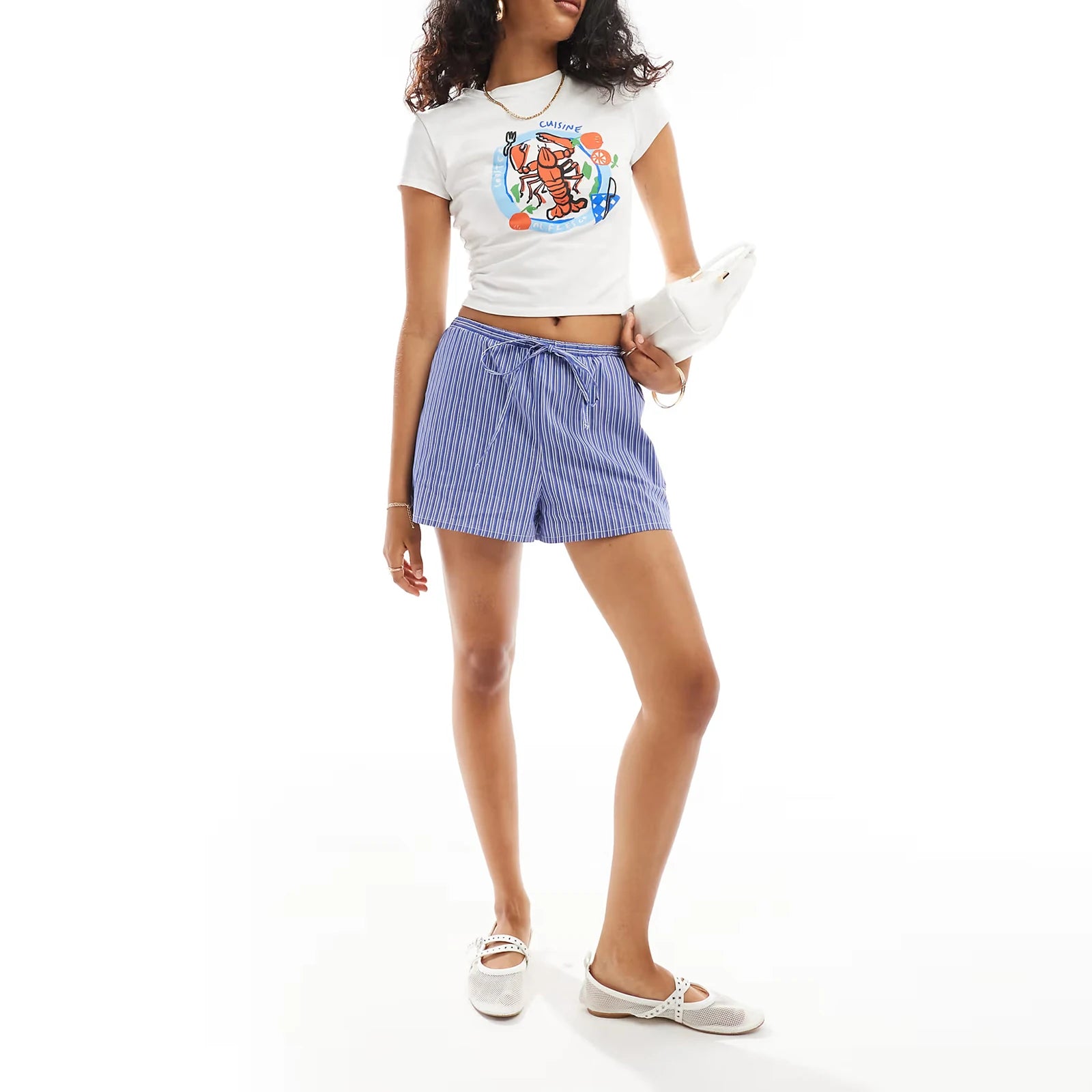 Woman wearing a white t-shirt with a colorful design and blue shorts