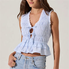 Light blue ruffled top worn by a person on a plain background