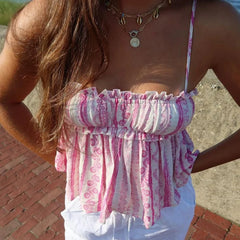 Woman wearing a pink and white patterned top with a blurred background