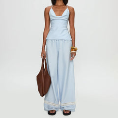 Woman wearing a light blue striped outfit holding a brown bag