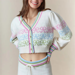 Woman wearing a colorful knitted cardigan against a beige background