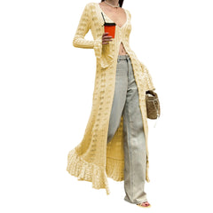 Person wearing a yellow crochet cardigan over a white top, holding a red cup.