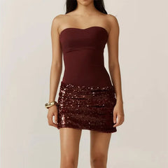 Woman wearing a strapless burgundy top and sequin skirt